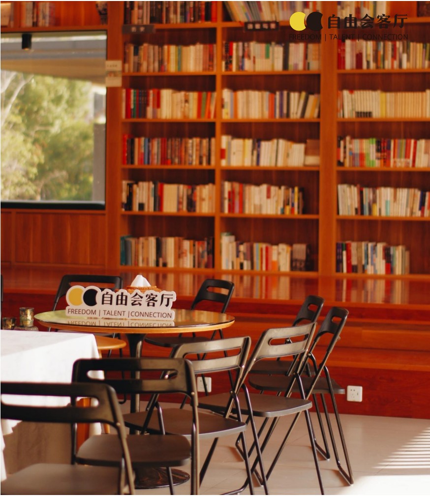 A Freelance Salon gathering space with bookshelves, chairs and a community sign